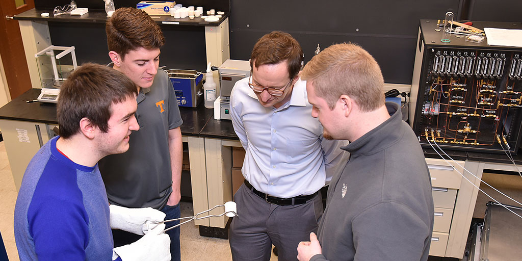 Ryan Unger, Trey Augustine, Maik Lang, and Will Cureton inspect materials synthesized at extreme conditions.